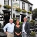 Steve and Josie Slayford, former owners of The Running Horses pub in Surrey, now become its lessees after a successful sale to Brakspear in a deal finalised by chief executive Tom Davies (r)