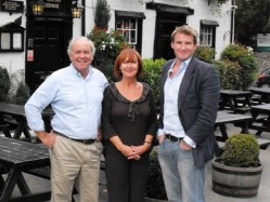 Steve and Josie Slayford, former owners of The Running Horses pub in Surrey, now become its lessees after a successful sale to Brakspear in a deal finalised by chief executive Tom Davies (r)